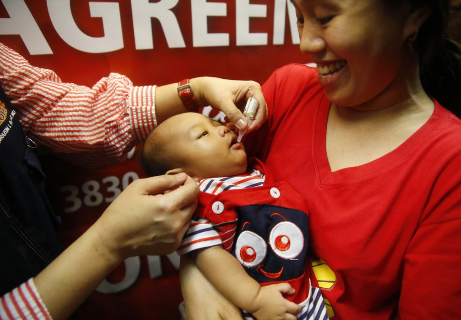 A baby in the Philippines gets inoculated against polio with a live vaccination.