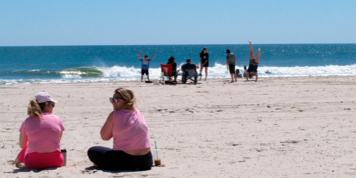 A pair of women and a family six feet apart at the New Jersey Shore.