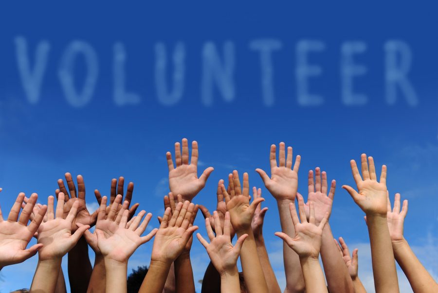 Picture of hands in the sky, in front of the words volunteer. From lawpracticetoday.org