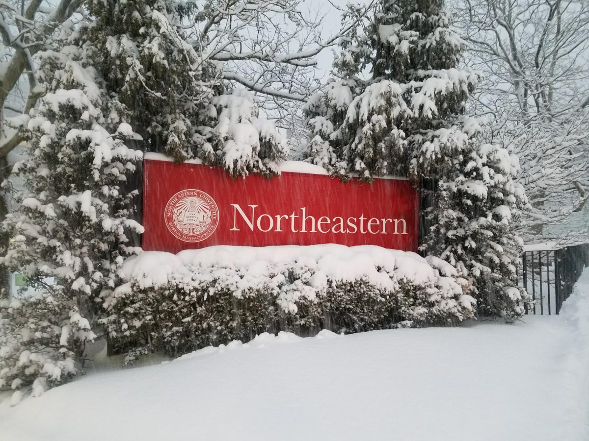 Northeastern University sign in the snow outside Ruggles Station during a blizzard, courtesy of Wikimedia Commons.